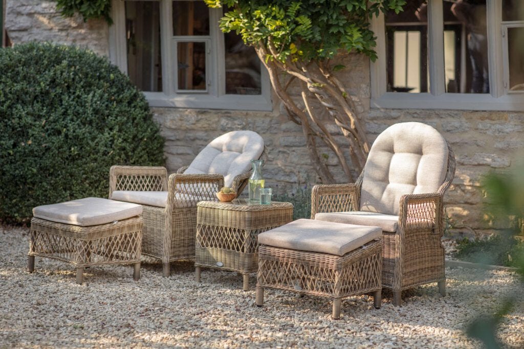 RHS Rosemoor garden furniture companion set in a garden with greenery and chippings on the floor.