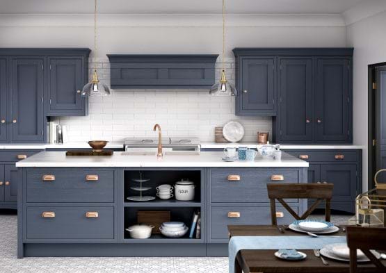Laura Ashley Helmsley kitchen with navy painted cabinets and white stone worktop and cooper handles 