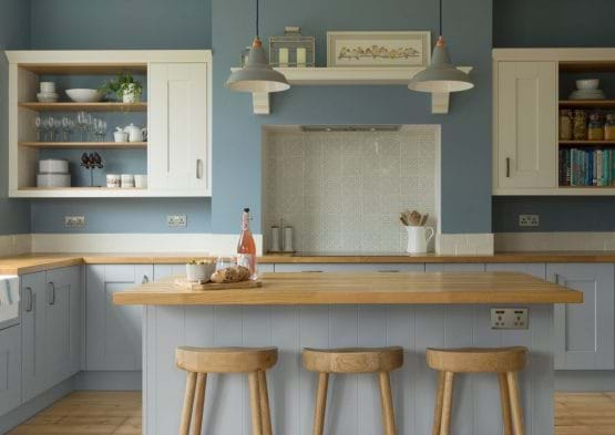 Laura Ashley Whitby kitchen with two tone painted cabinets in blue and white with island and wooden worktops