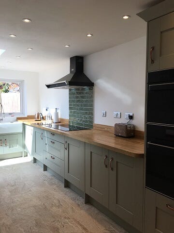 Painted gallery kitchen in sage green colour scheme with wood worktops 